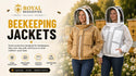 Two women wearing beekeeping jackets in an outdoor apiary setting. One jacket is tan/beige and the other is white, both with full face shields.